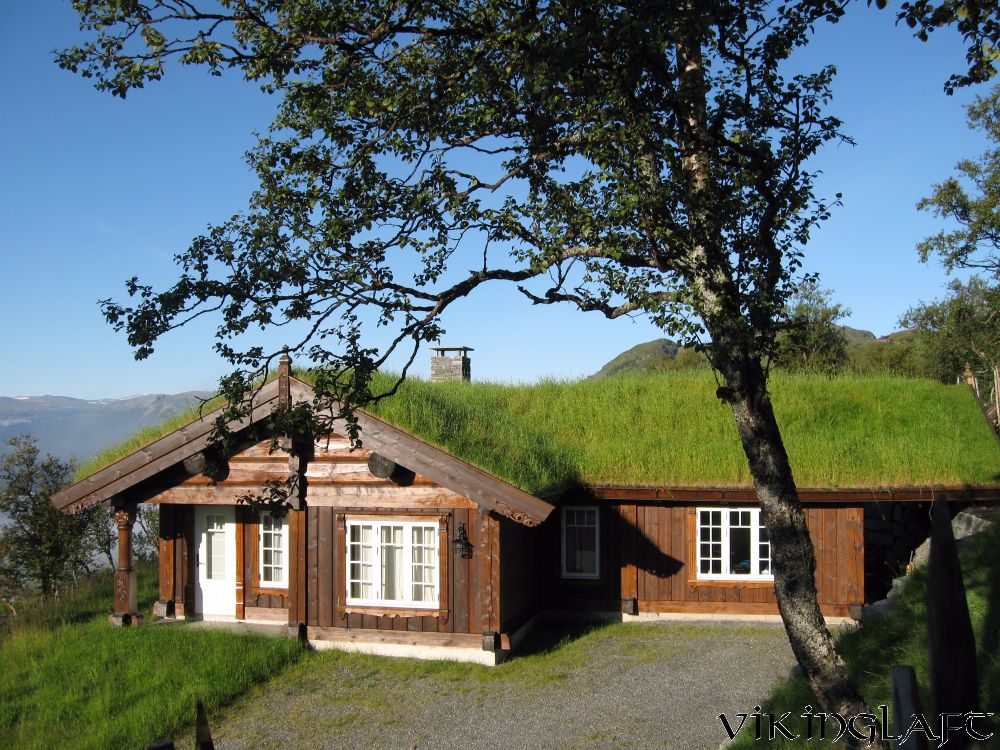 Laftehytte med torvtak og utskårne stolper på Oppdalsfjellet om sommeren