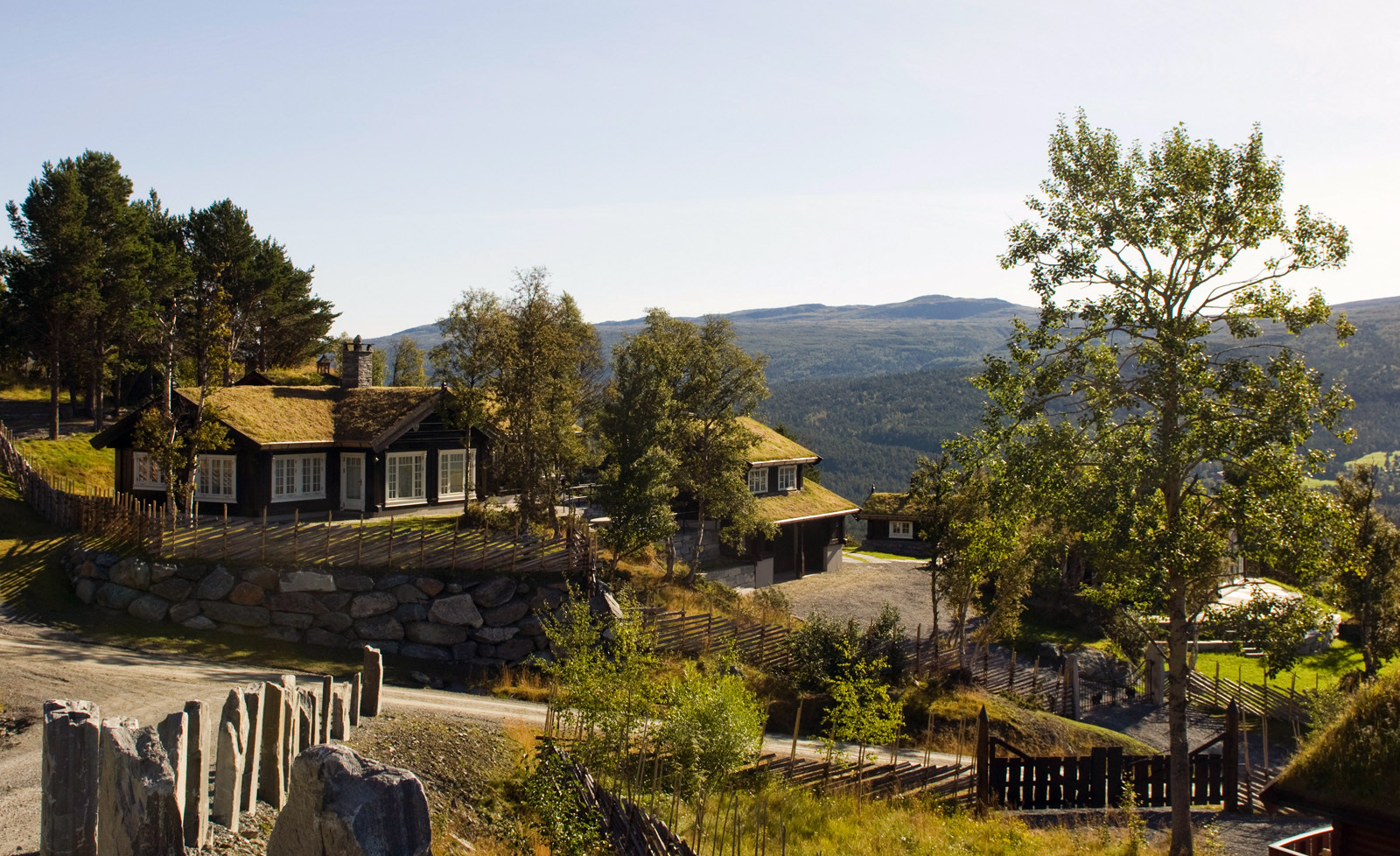 Håndlaftet tømmerhytte med torvtak i fjellet i Oppdal ved skumringen